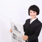 英字新聞を読む女性